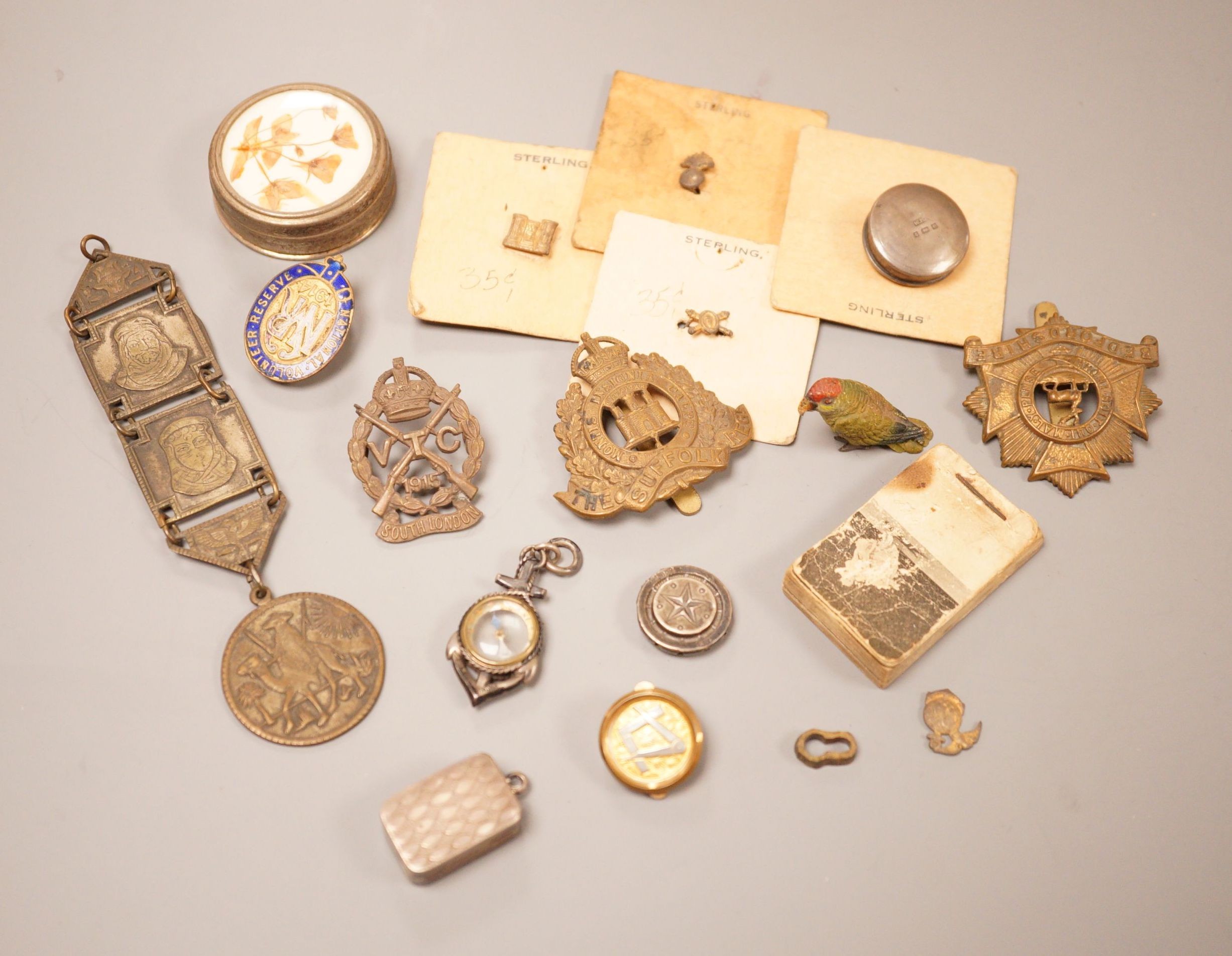 A selection of various miscellaneous items, to include a George III silver vinaigrette, a military pin badge, an Edwardian flick book, a cold painted parrot, and others.